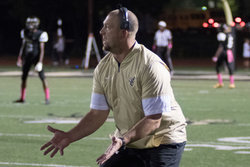Sprayberry’s Head football coach Brett Vara communicates with his team, during the game, between the River Ridge Knights and... -WIlliam Lofton