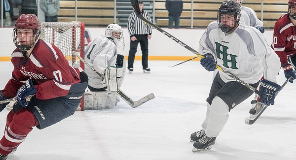 Hamden Hall Defenseman Ryan Reynolds defends against Avon Old Farms forward as Goalie Michael Coggins protects the post.